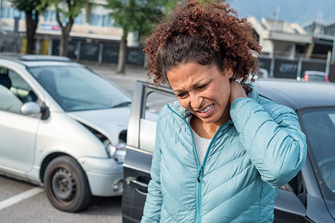 Una mujer con dolores de cuello después de un accidente.