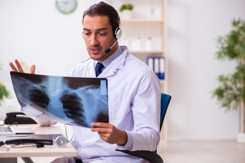Un doctor viendo las radiografías de un paciente.