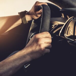 persona con las manos en el volante