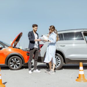 dos personas hablando en la escena de un accidente automovilístico menor