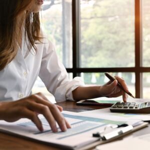Persona que usa una calculadora en un escritorio