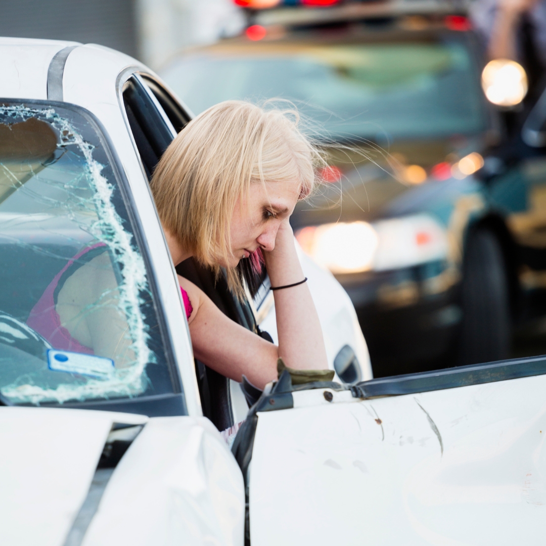 Woman sitting in her car after an accident