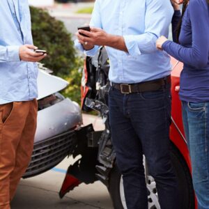 personas intercambiando información de seguros después de un accidente automovilístico