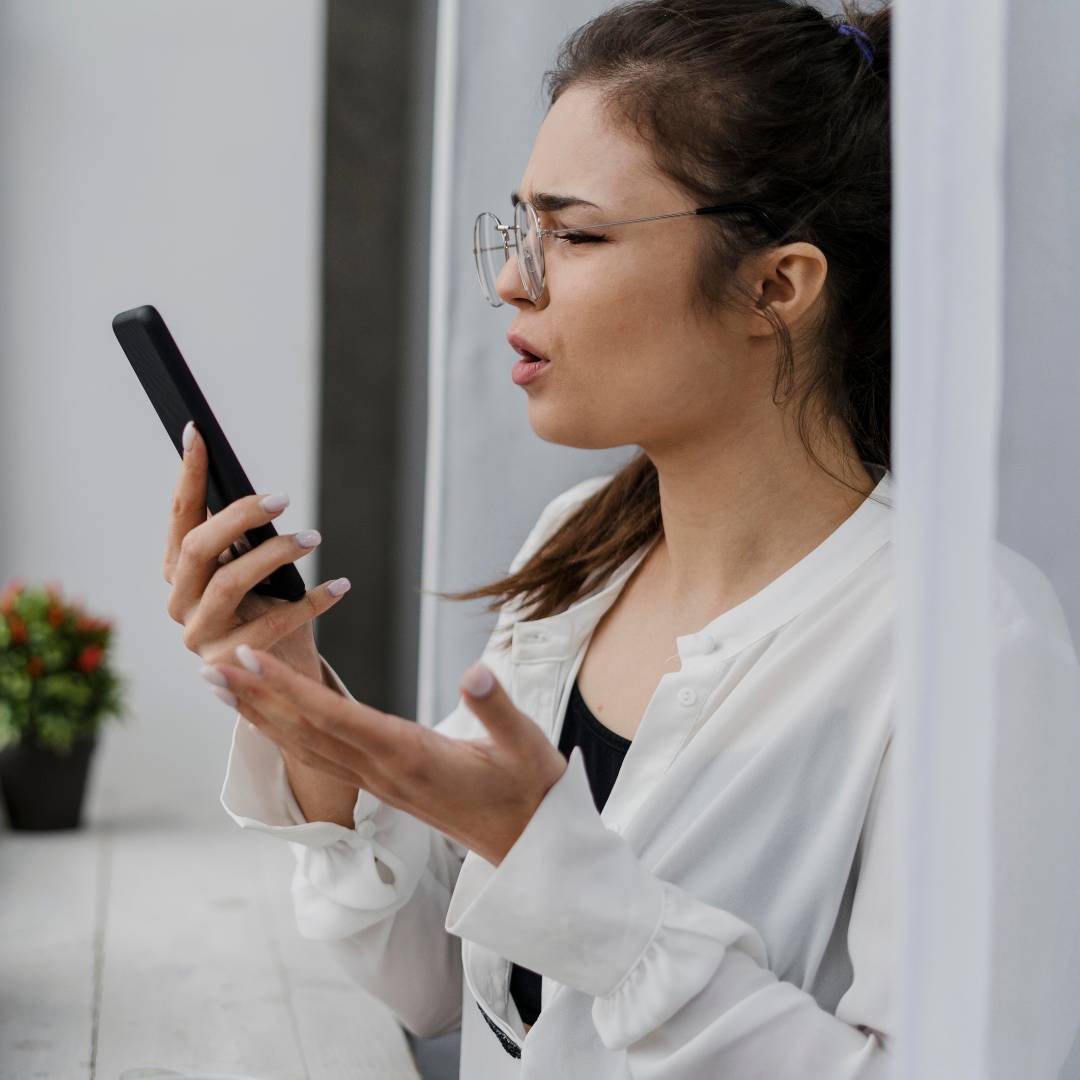 A woman on her phone looking frustrated
