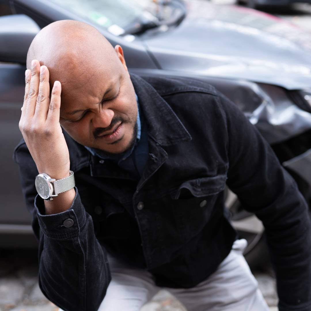 A man holding his head after being in a car accident