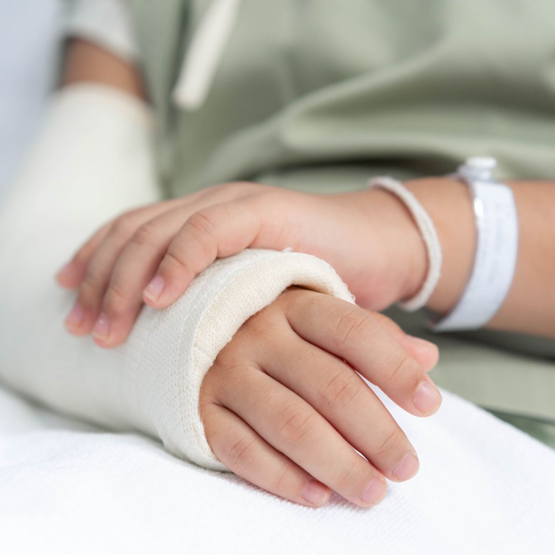in hospital bed with arm in cast