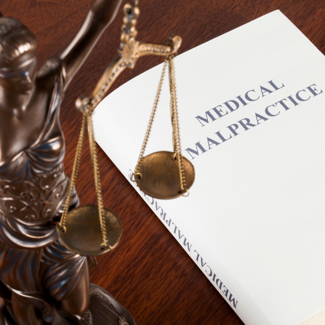 medical malpractice book next to justice scales