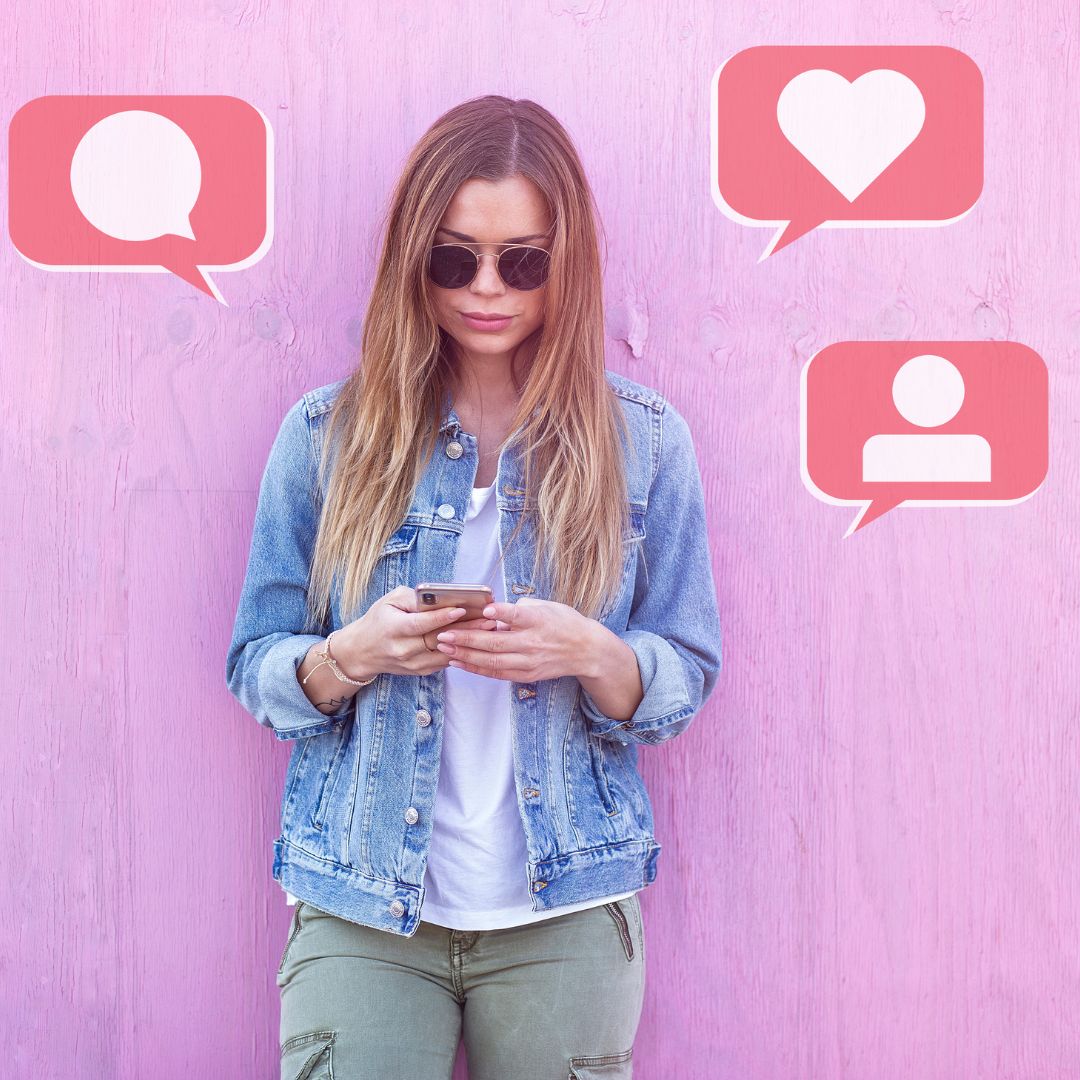 Women holding a phone while standing up against a wall with graphics of social media comments and likes around her. 
