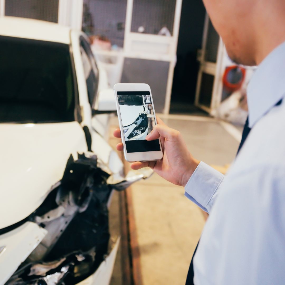 Person taking a picture of a crashed car