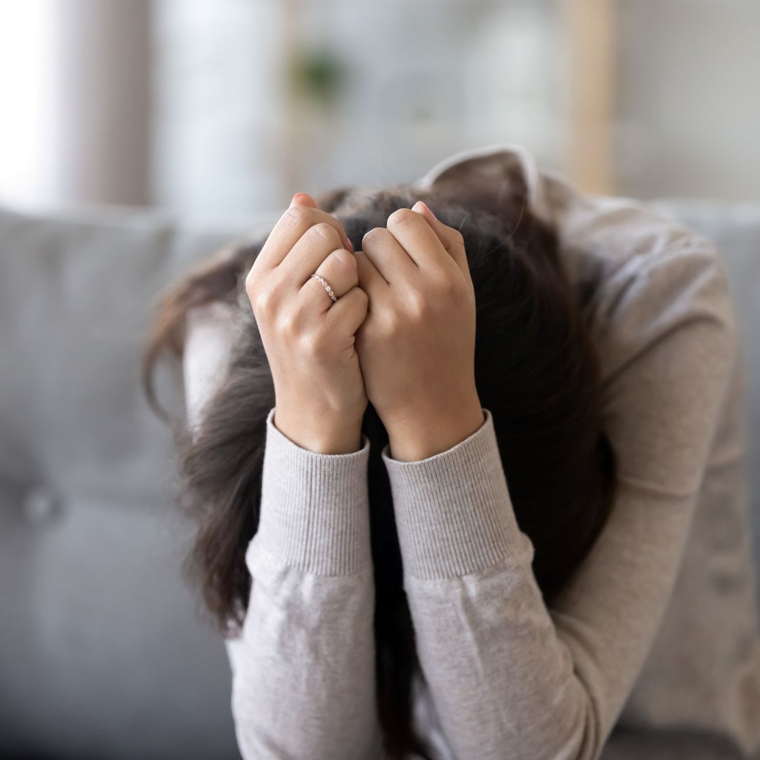 Women grabbing her head in stress