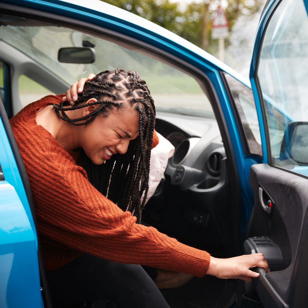 A women grabbing her neck after a crash