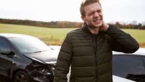 Man grabbing his neck after a car crash