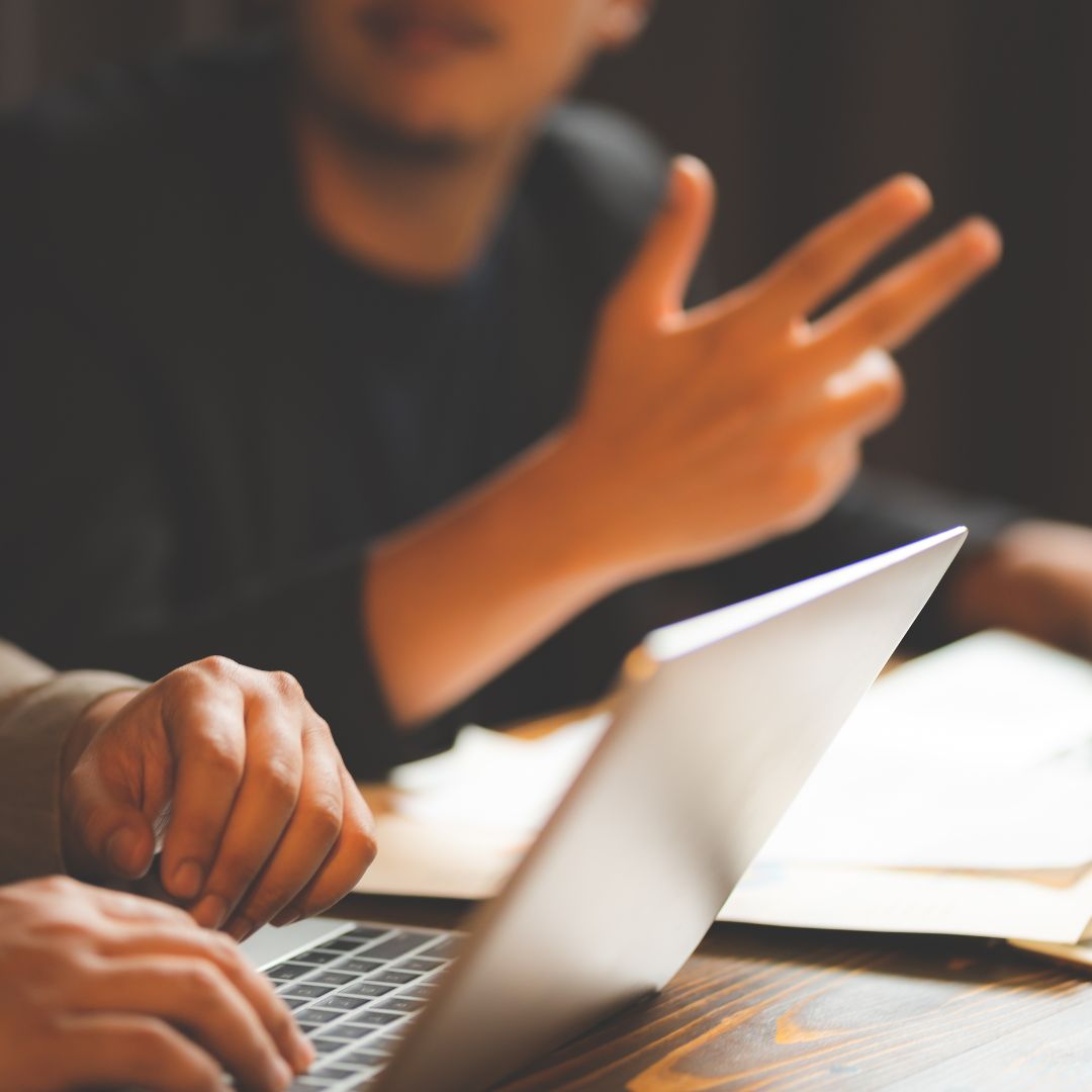 Two people discussing with a laptop in front of them
