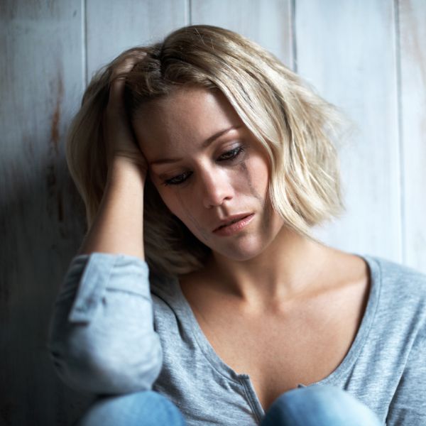 Women holding her head with tears on her face