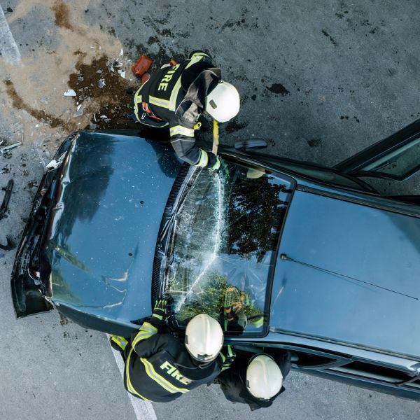 bomberos rescatando a alguien de un coche accidentado