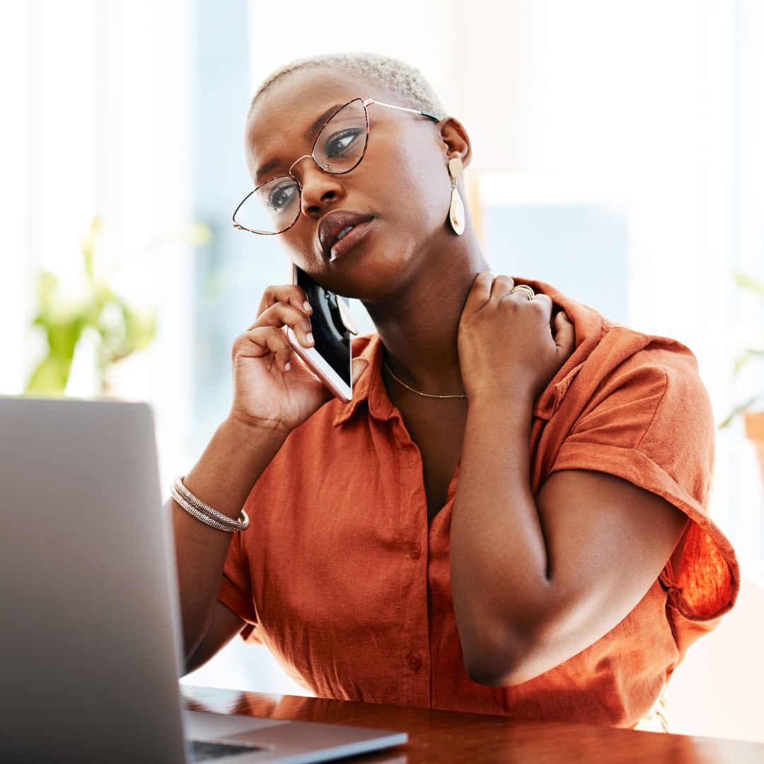 A woman on the phone holding her neck