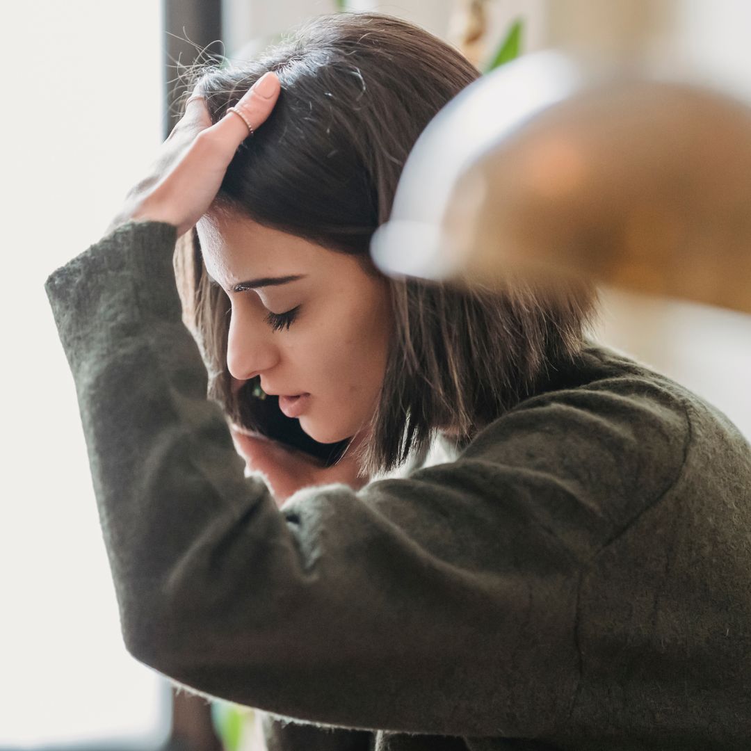Injured woman holding her head while on phone