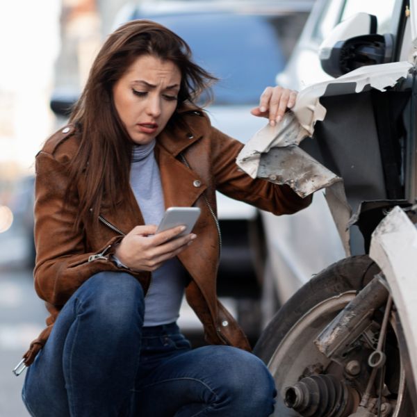 A women on the phone after having her car hit in an accident