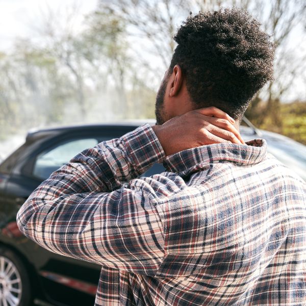 A man grabbing his neck after a car accident