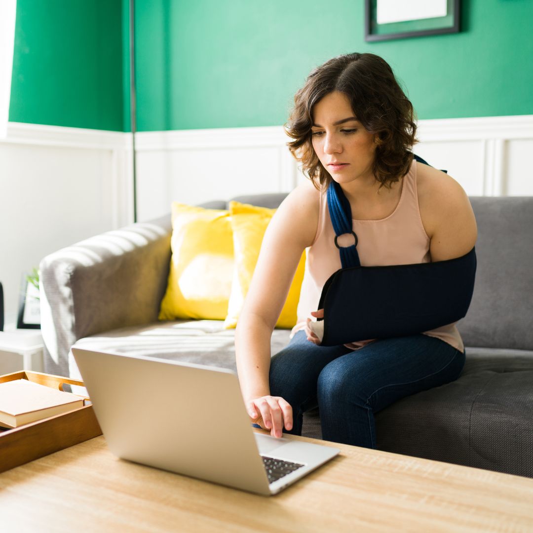 Injured woman sending an email on her computer