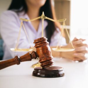 A women next to a judge gavel and a scale