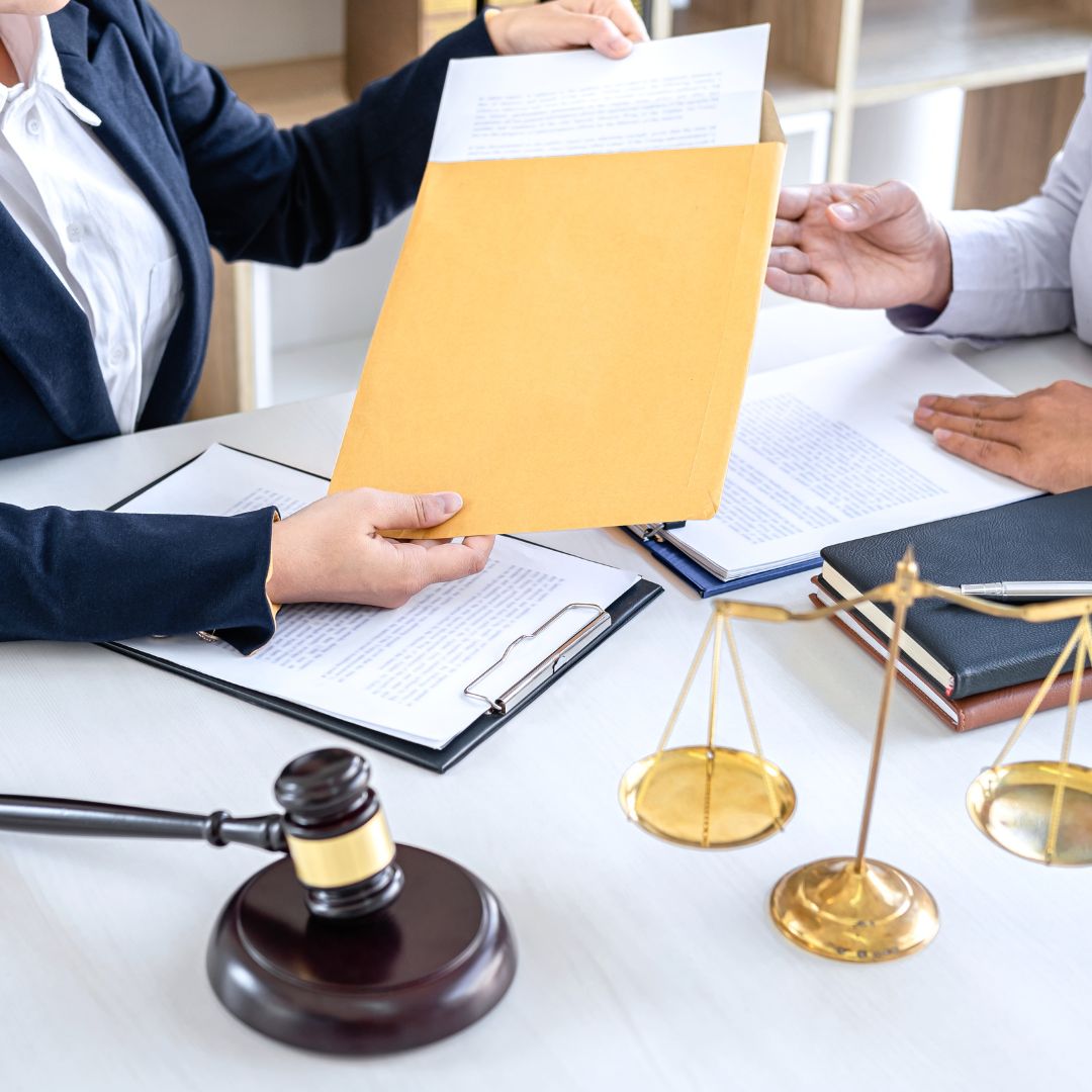 lawyer and client removing a paper from an envelope