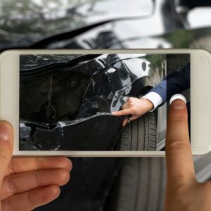 A person taking a picture of a crashed vehicle