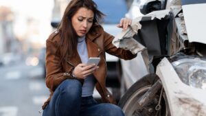 A women standing next to a crashed vehicle