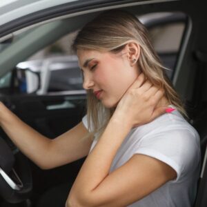 Women sitting in her car with neck pain from whiplash