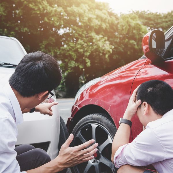 Two men looking at the aftermath of a car crash