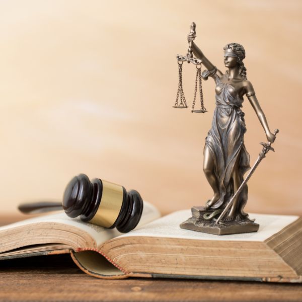 Estatua de la Dama de la Justicia encima de un libro