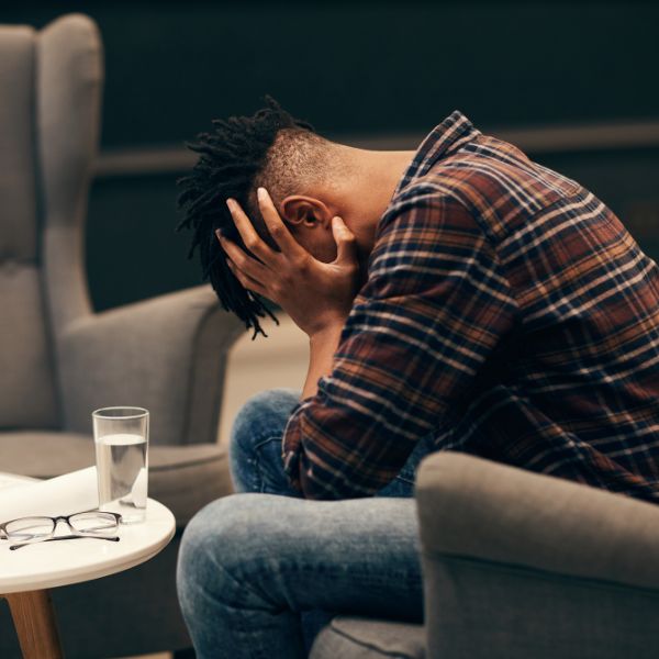 A man holding his face to represent frustration
