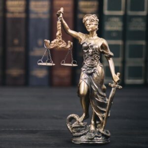 Lady justice statue in front of various books