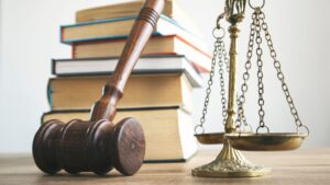 A judge gavel and scale next to a stack of books
