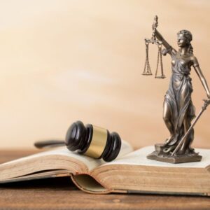 Estatua de la Dama de la Justicia encima de un libro