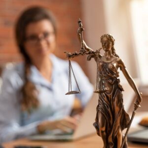 Estatuto de la Dama de la Justicia con una mujer al fondo