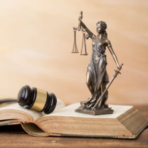 Una dama de la justicia encima de un libro de derecho