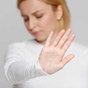 Una mujer con la mano en alto representando "negarse"
