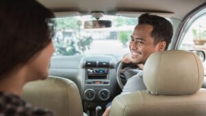Taxista sonriendo a su pasajero