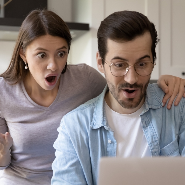 A couple starting at a laptop in awe