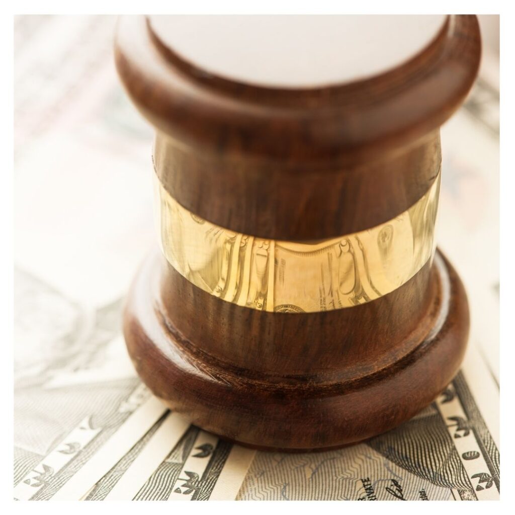 A judge gavel atop of money