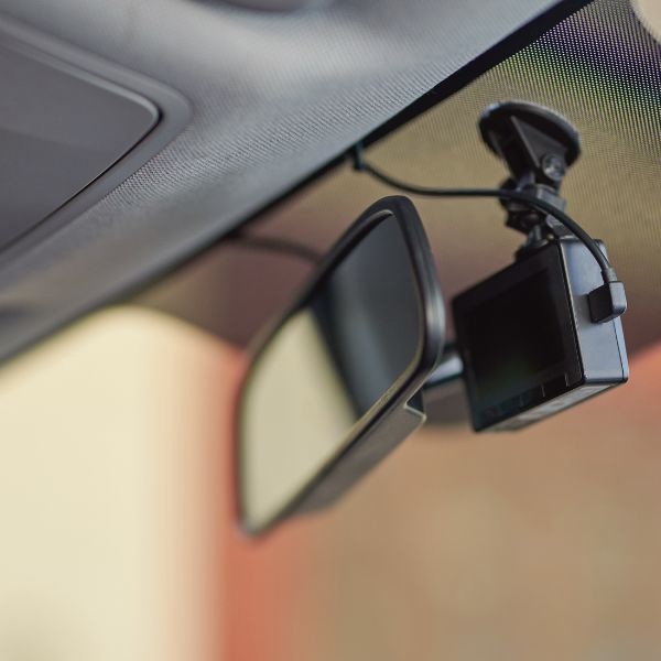 A dashcam on a rearview mirror