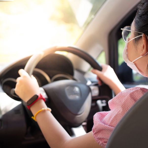 Una mujer conduciendo con el sol en los ojos
