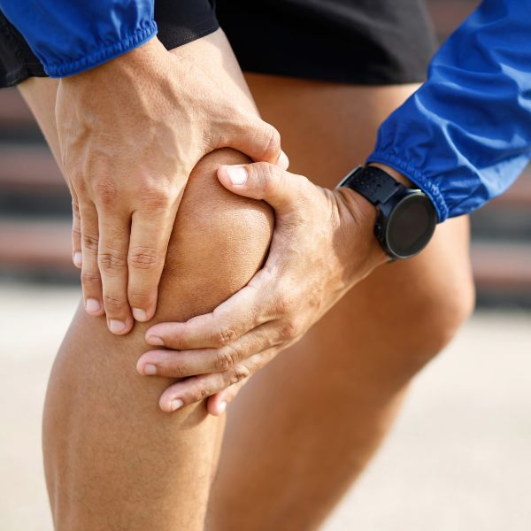 A person grabbing their knee in pain