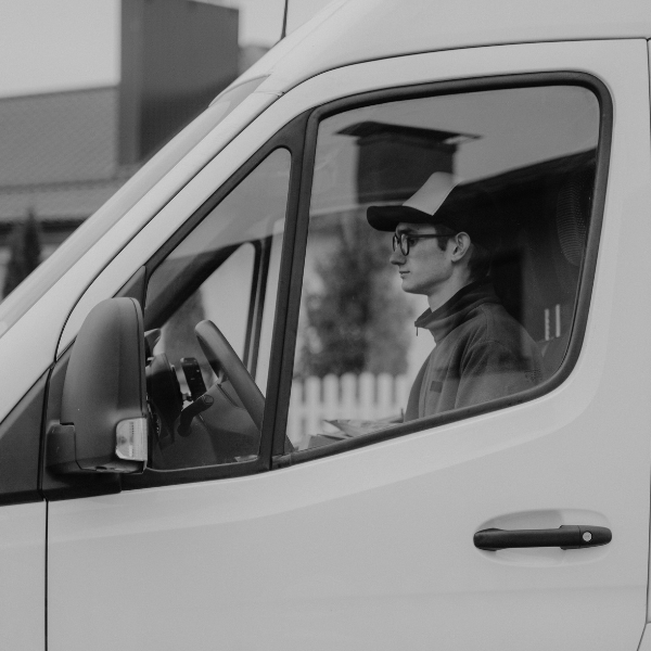 Un hombre conduciendo un coche de trabajo tecleando en un portátil
