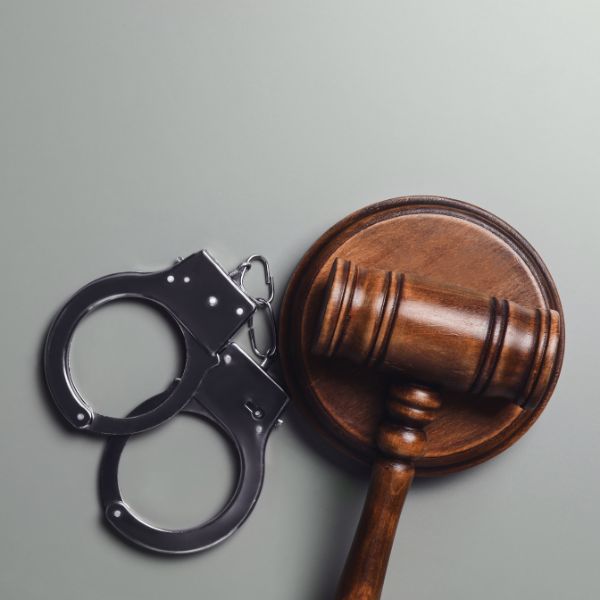 A judge gavel next to handcuffs