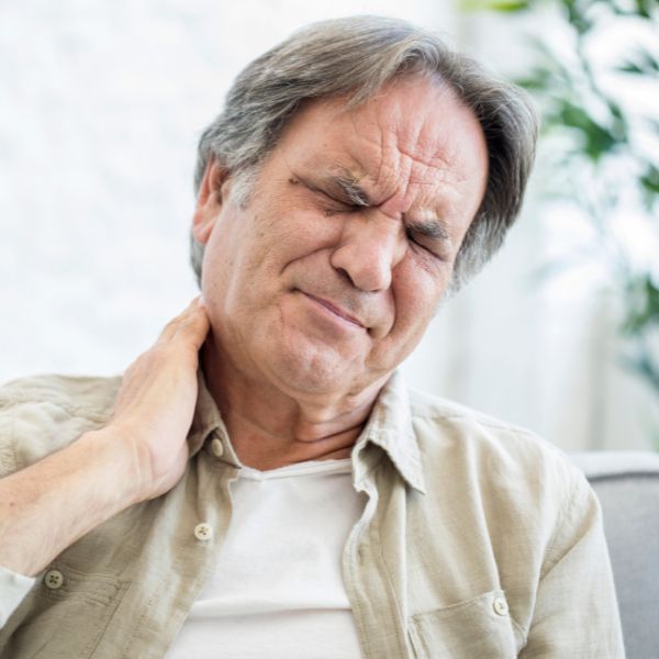 Una persona agarrándose el cuello con dolor
