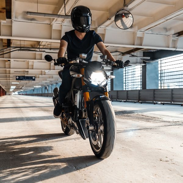 A person riding a motorcycle in a parking garage