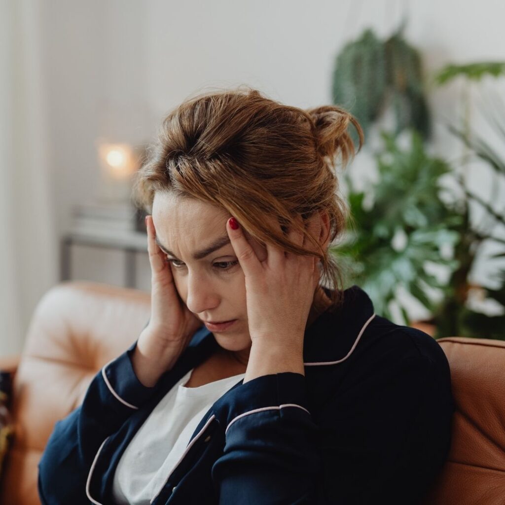 Una mujer agarrándose la cabeza con dolor