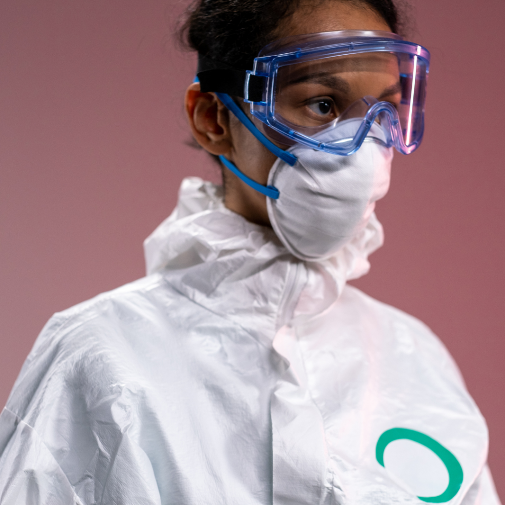 Mujer con traje de protección contra materiales peligrosos y máscara